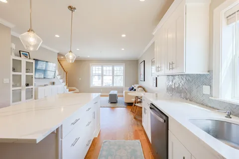 a large kitchen with kitchen island a large counter space a sink appliances and a window