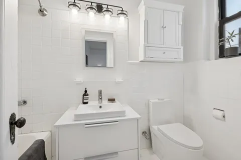 a bathroom with a sink a toilet and mirror