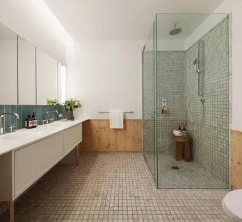 a bathroom with a shower a toilet a sink a mirror and vanity