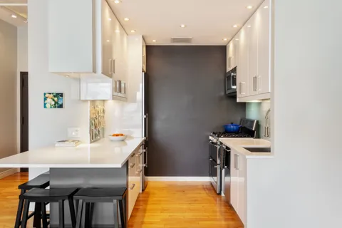a kitchen with kitchen island a stove a table and chairs in it
