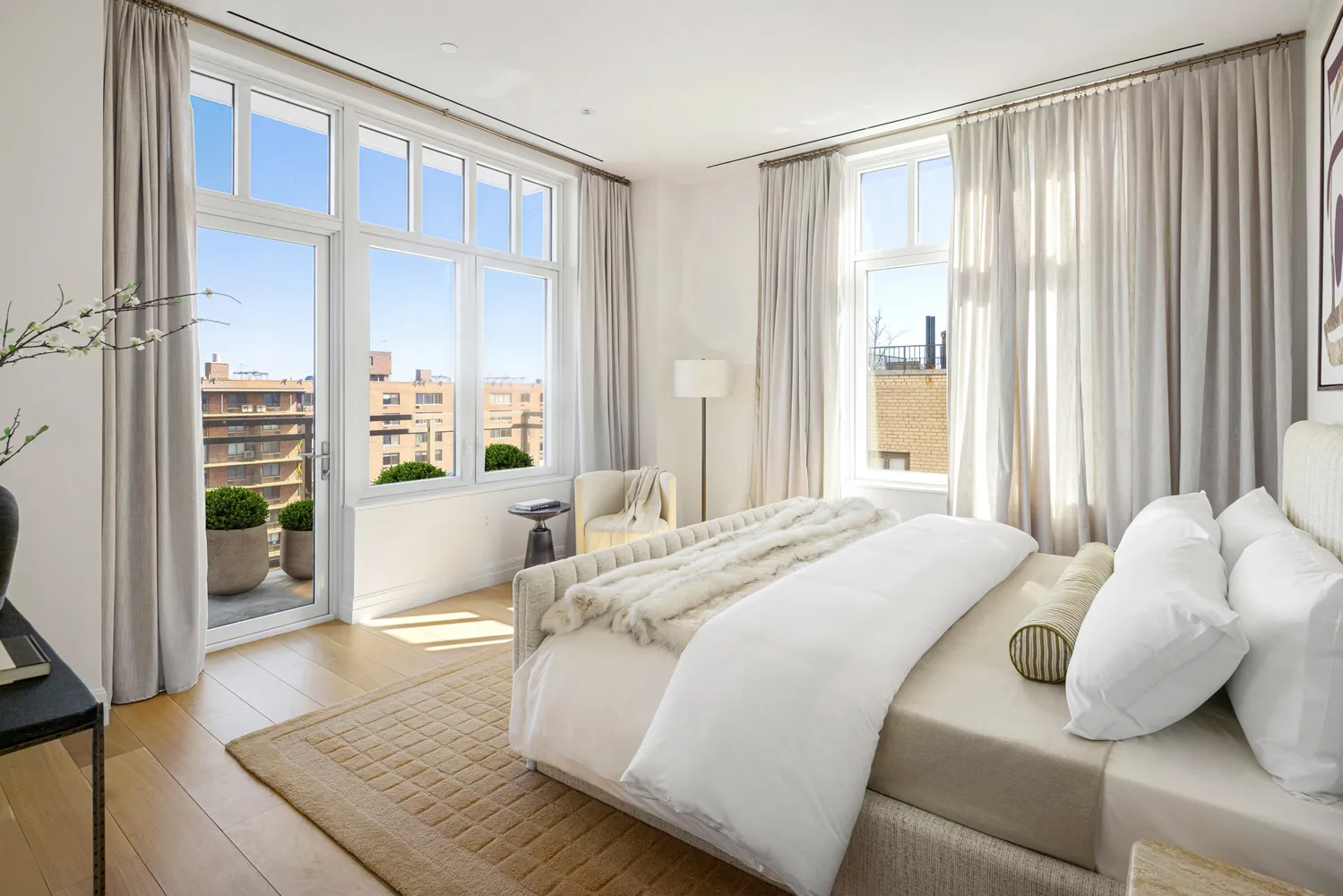 a bed sitting in a spacious bedroom next to a window