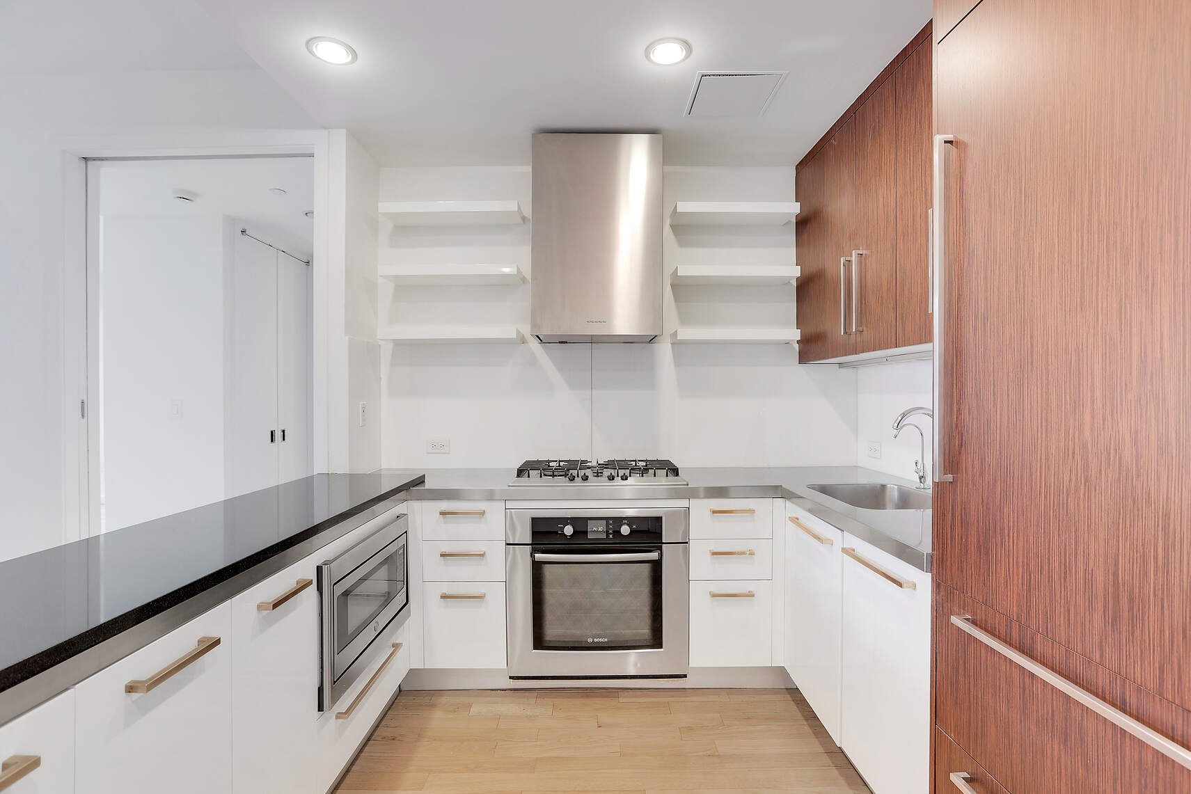 133 West 22nd Street, Unit 7H Manhattan, NY 10011 - Photo 6 of 21 a kitchen with stainless steel appliances granite countertop white cabinets and a stove top oven