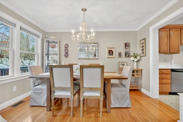 a view of a dining room with furniture a chandelier and wooden floor