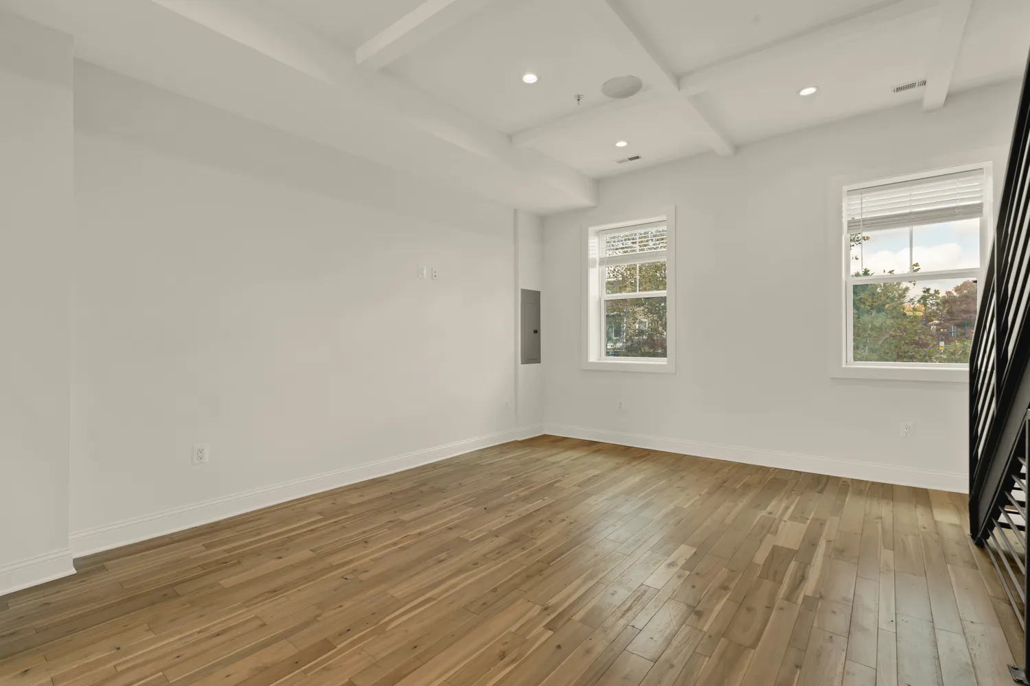 an empty room with wooden floor and windows