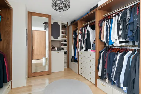 a view of walk in closet with clothes and shoes
