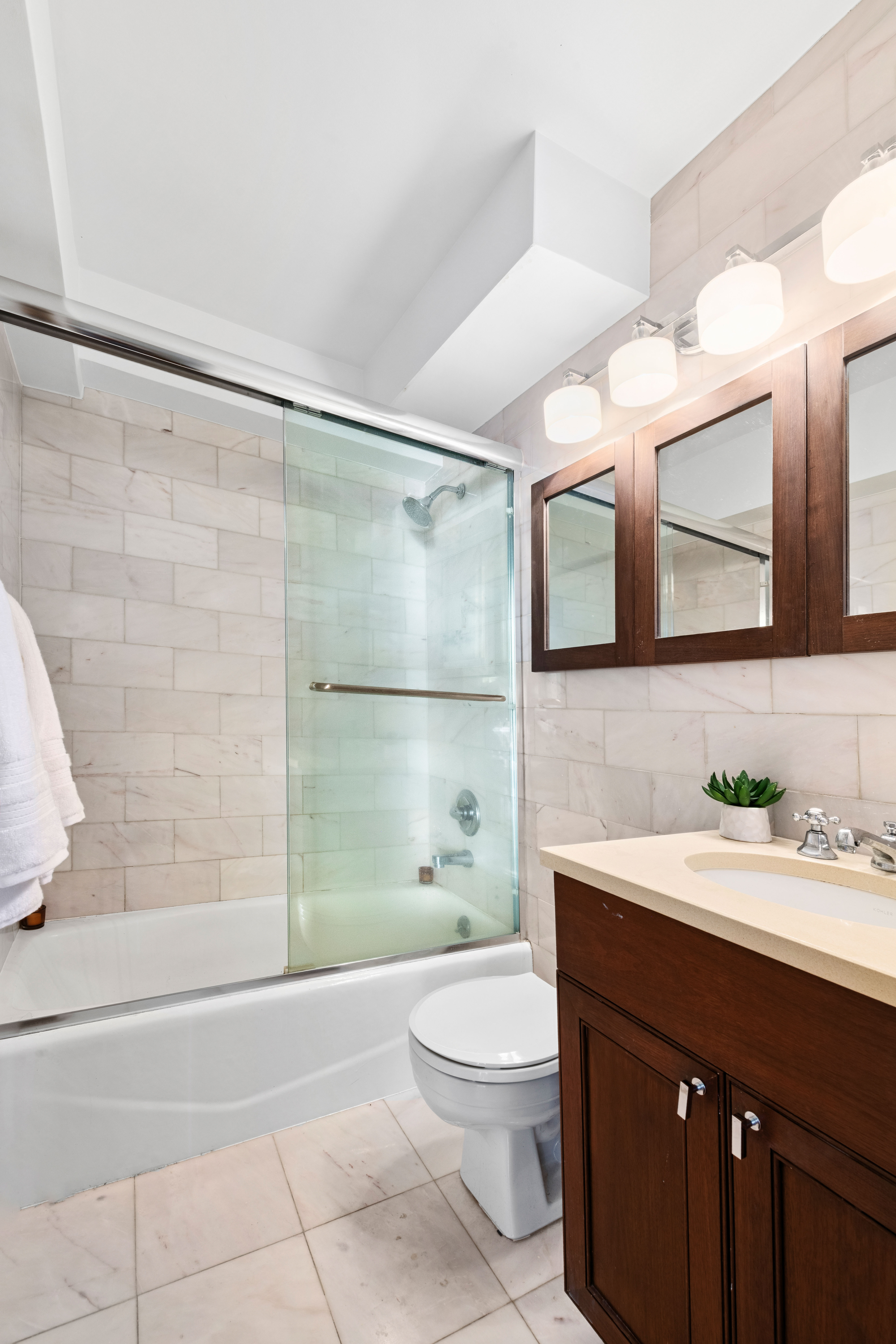205 East 77th Street, Unit 3A Manhattan, NY 10075 - Photo 7 of 9 a bathroom with a sink a toilet and shower