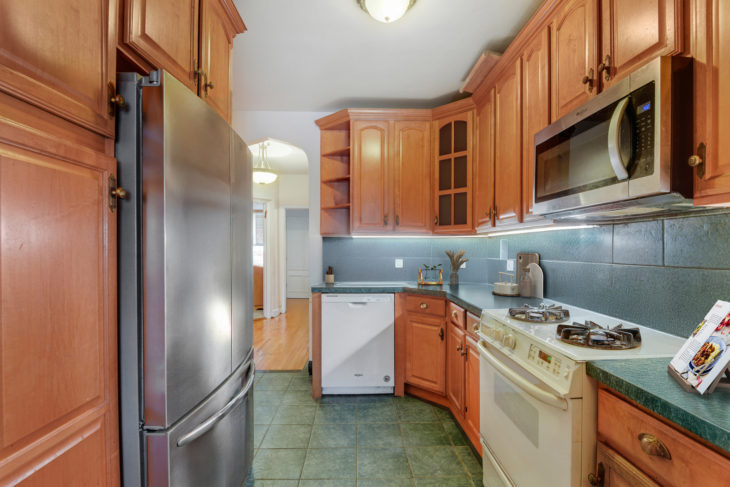 233 Battery Avenue Brooklyn, NY 11209 - Photo 3 of 17 a kitchen with stainless steel appliances granite countertop a stove a refrigerator and a microwave