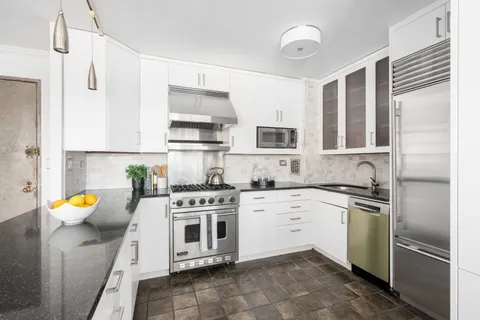 a kitchen with stainless steel appliances a stove a sink and cabinets
