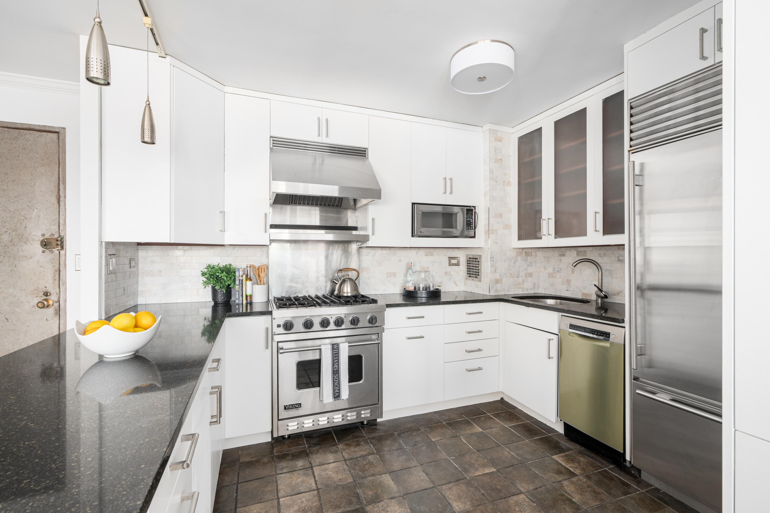 360 West 22nd Street, Unit 15C-14C Manhattan, NY 10011 - Photo 6 of 16 a kitchen with stainless steel appliances a stove a sink and cabinets