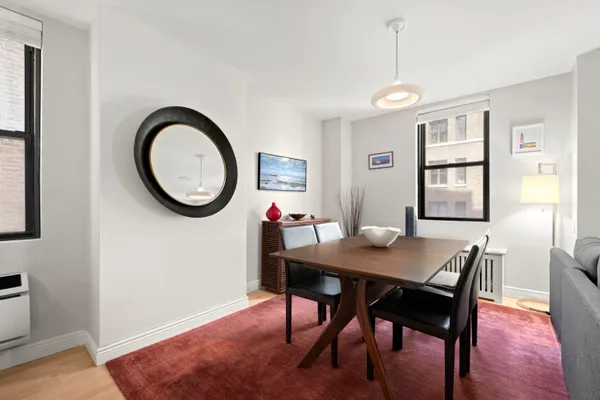 a dining room with wooden floor a chandelier a wooden table and chairs