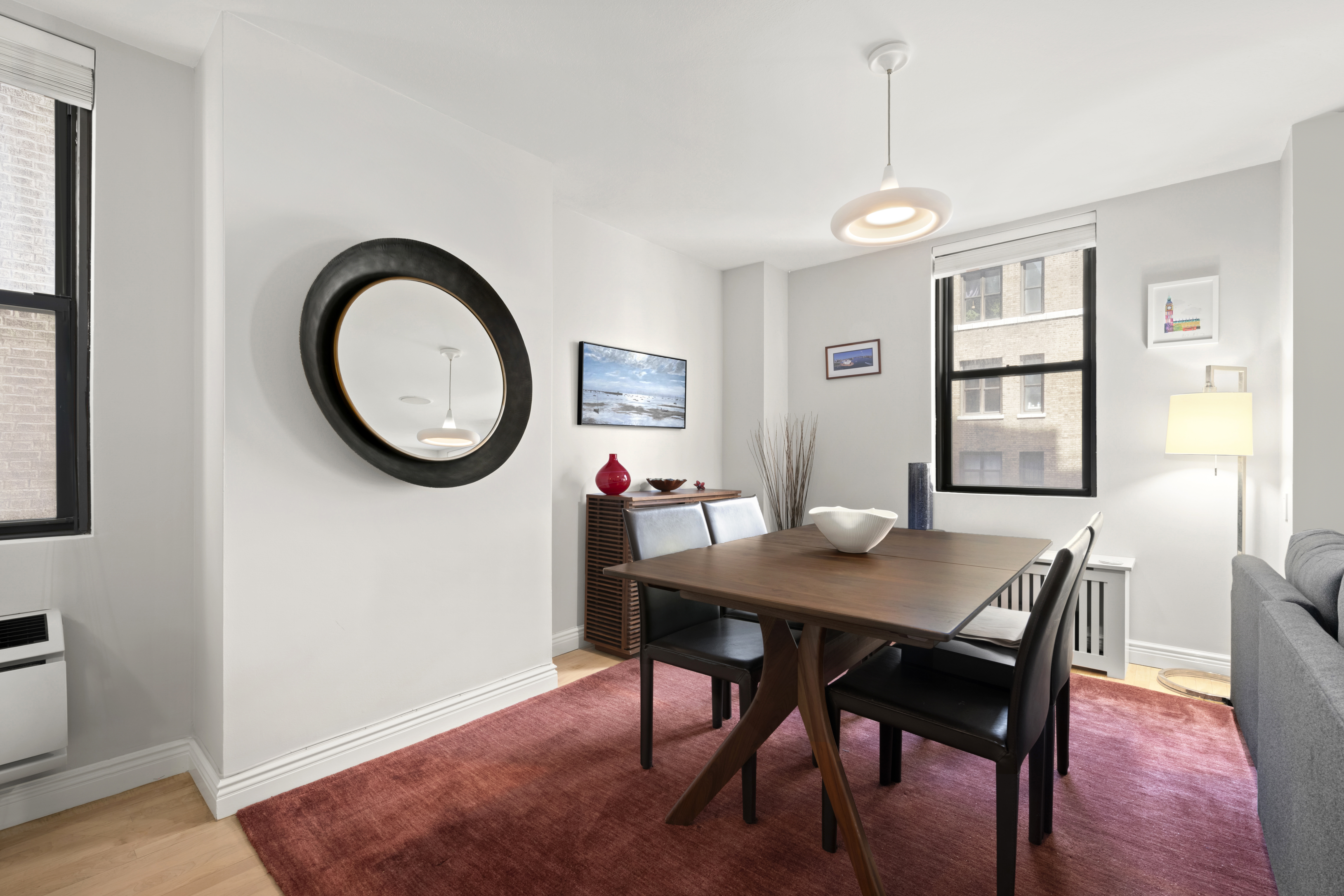 340 West 55th Street, Unit 5C Manhattan, NY 10019 - Photo 2 of 10 a dining room with wooden floor a chandelier a wooden table and chairs