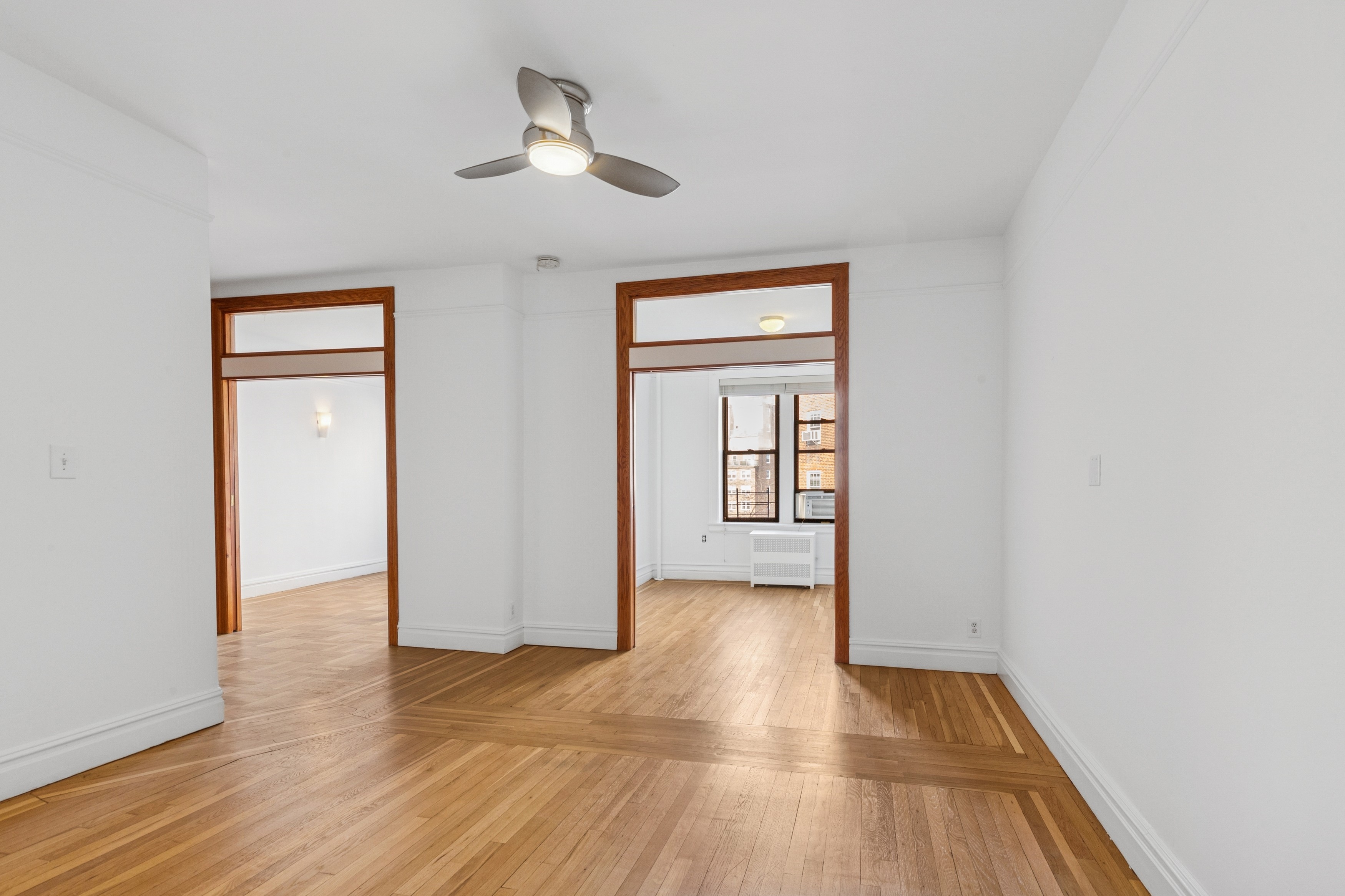 115 Cabrini Boulevard, Unit B51 Manhattan, NY 10033 - Photo 2 of 23 a view of an empty room with wooden floor and a window