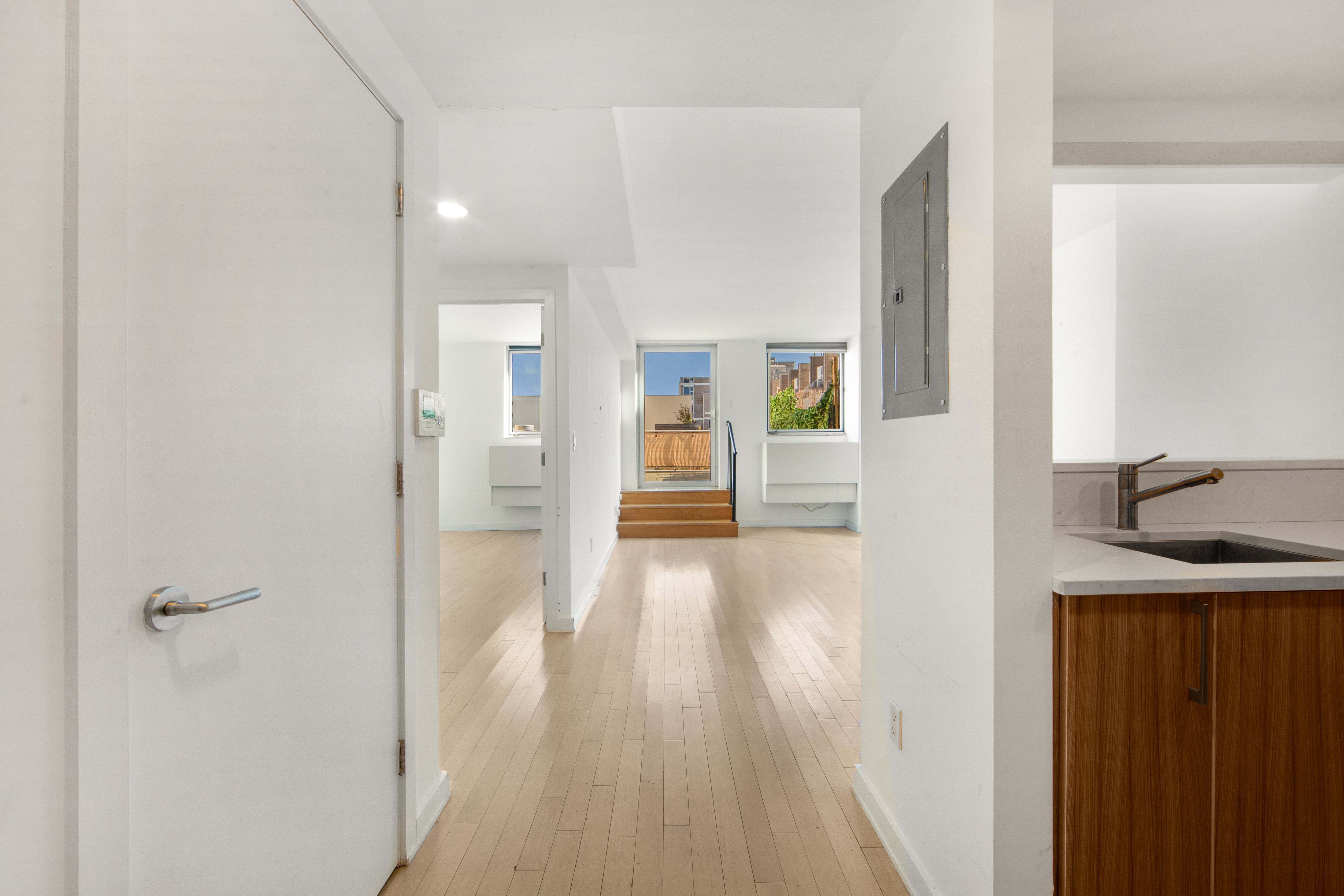 250 Bedford Avenue, Unit 129203 Brooklyn, NY 11249 - Photo 5 of 8 a view of a hallway with wooden floor and a bathroom