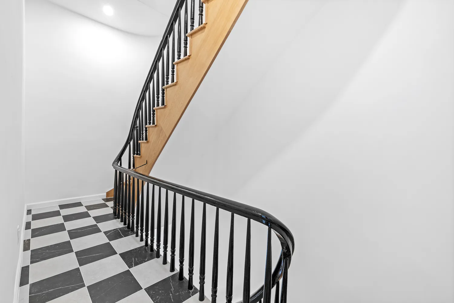 a view of a hallway with wooden floor and a black and white checkered floor