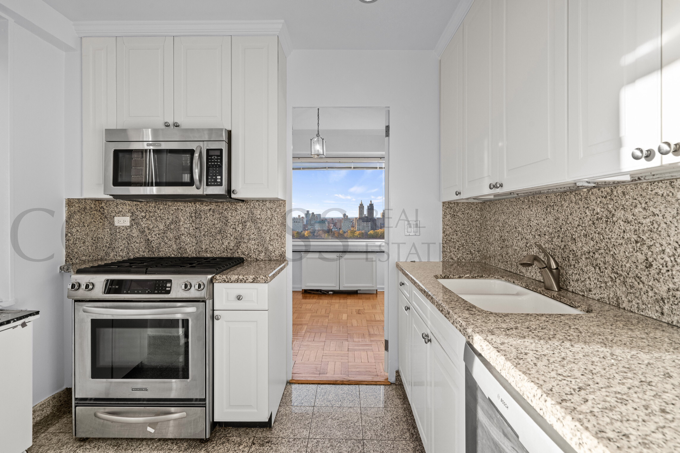 45 East 89th Street, Unit Undisclosed Manhattan, NY 10128 - Photo 6 of 10 a kitchen with granite countertop a stove sink and microwave
