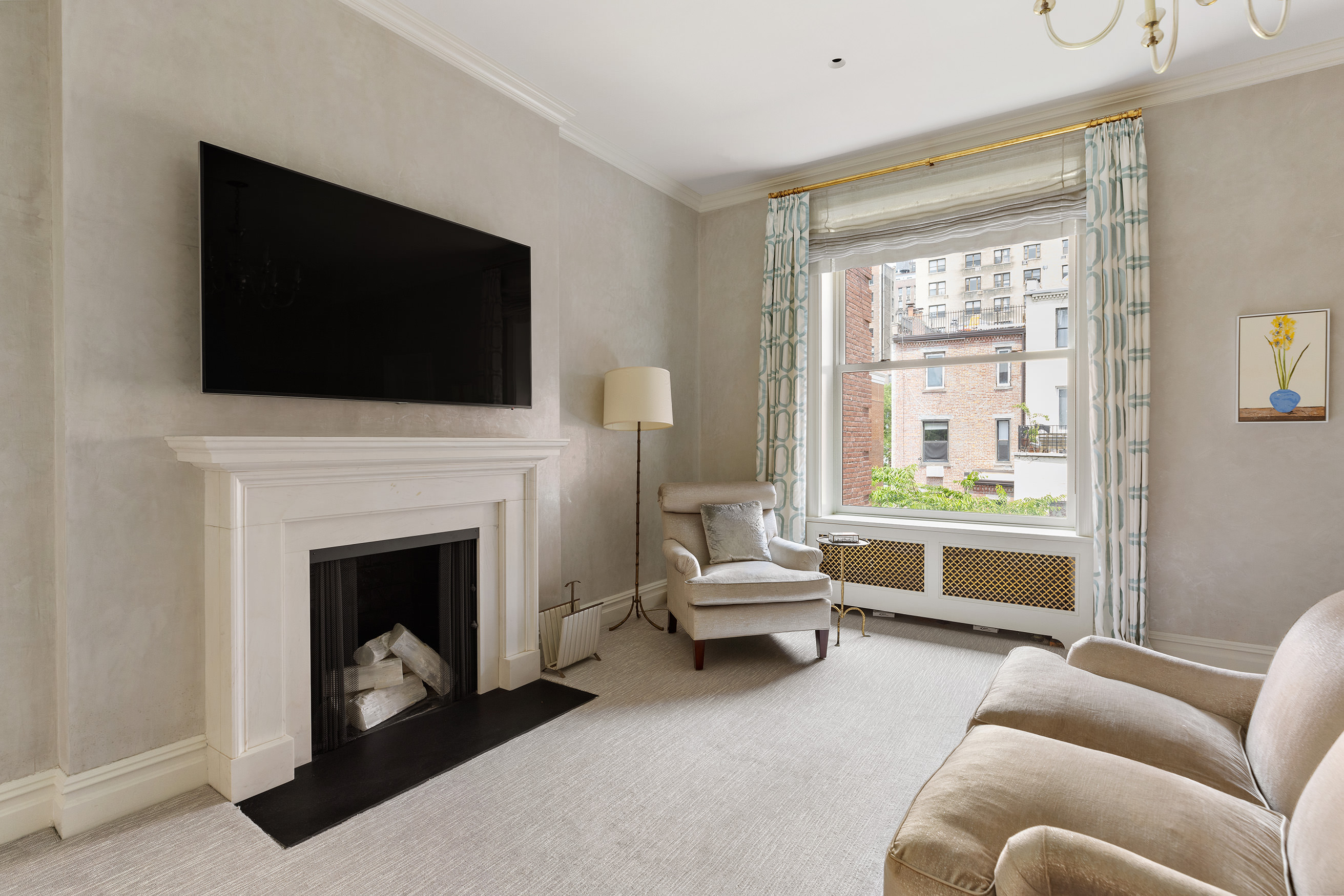 135 West 77th Street Manhattan, NY 10024 - Photo 16 of 32 a living room with furniture a flat screen tv and a fireplace
