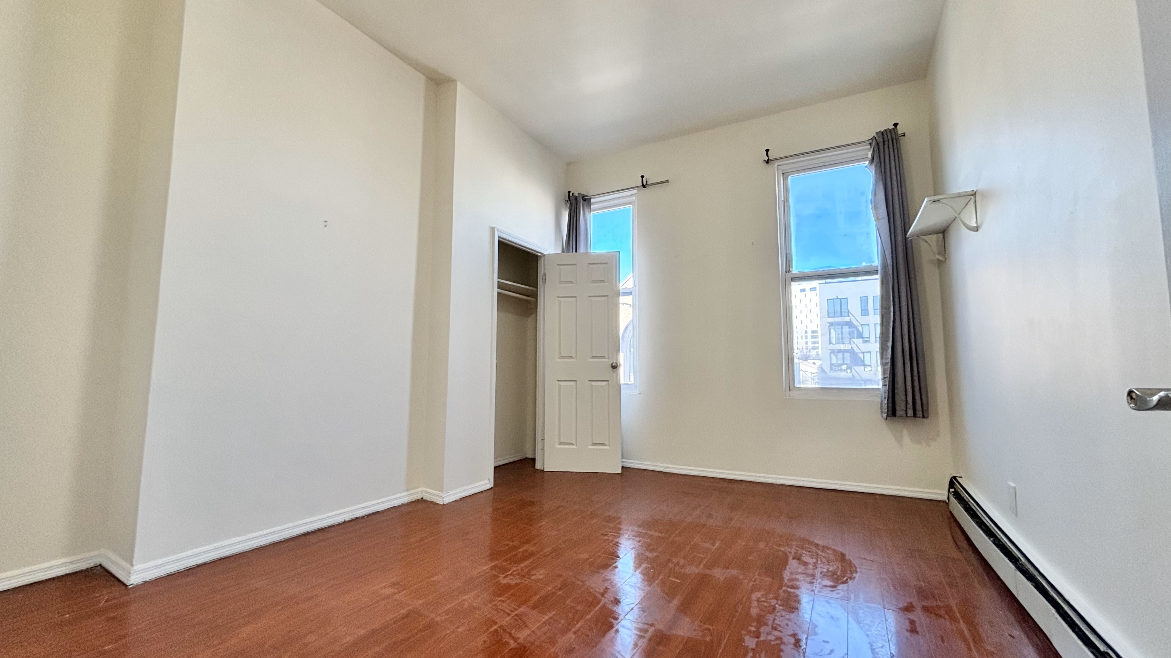 74 Himrod Street, Unit 2 Brooklyn, NY 11221 - Photo 9 of 16 an empty room with wooden floor and windows