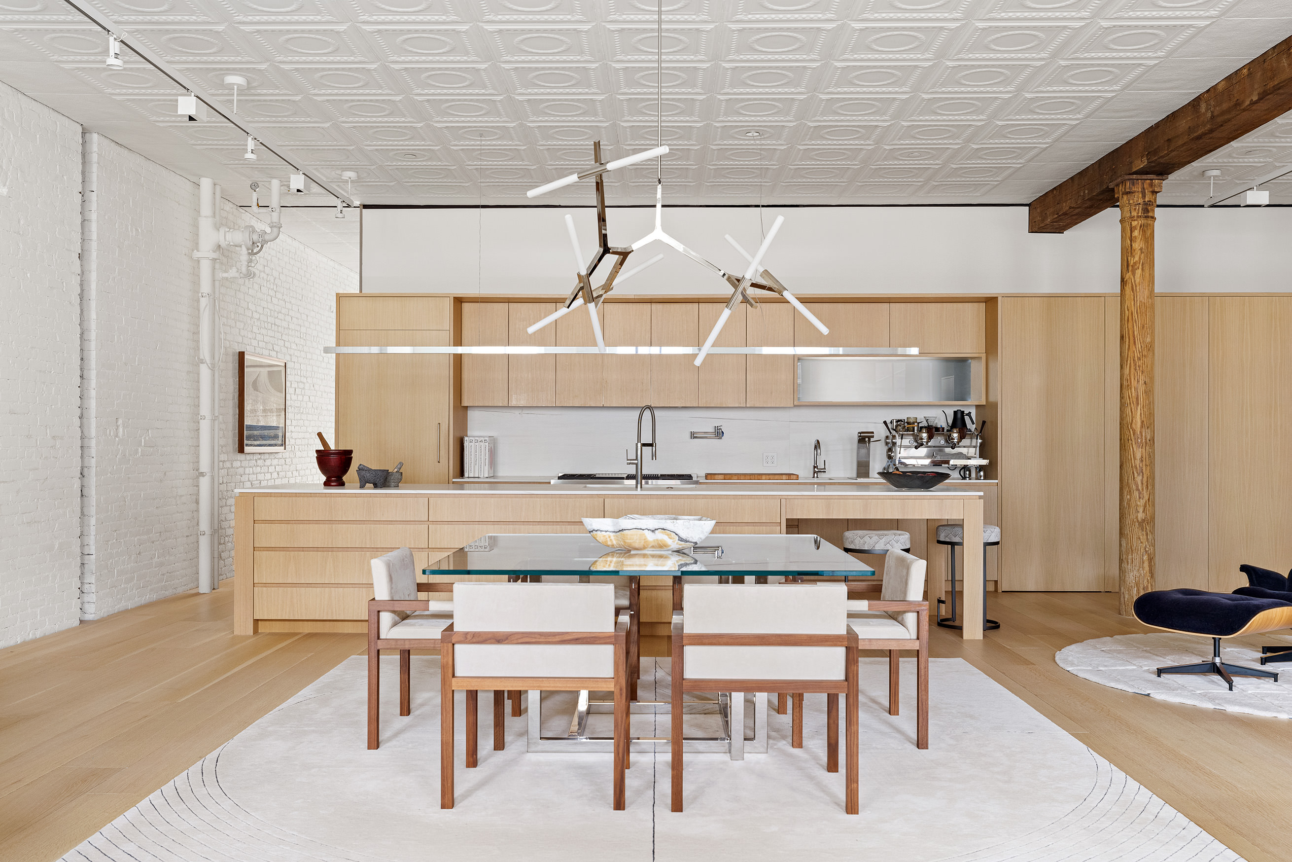 100 Grand Street, Unit 4 Manhattan, NY 10013 - Photo 3 of 13 a kitchen with a table chairs stove and cabinets