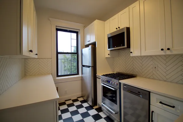 a kitchen with stainless steel appliances a stove microwave and sink