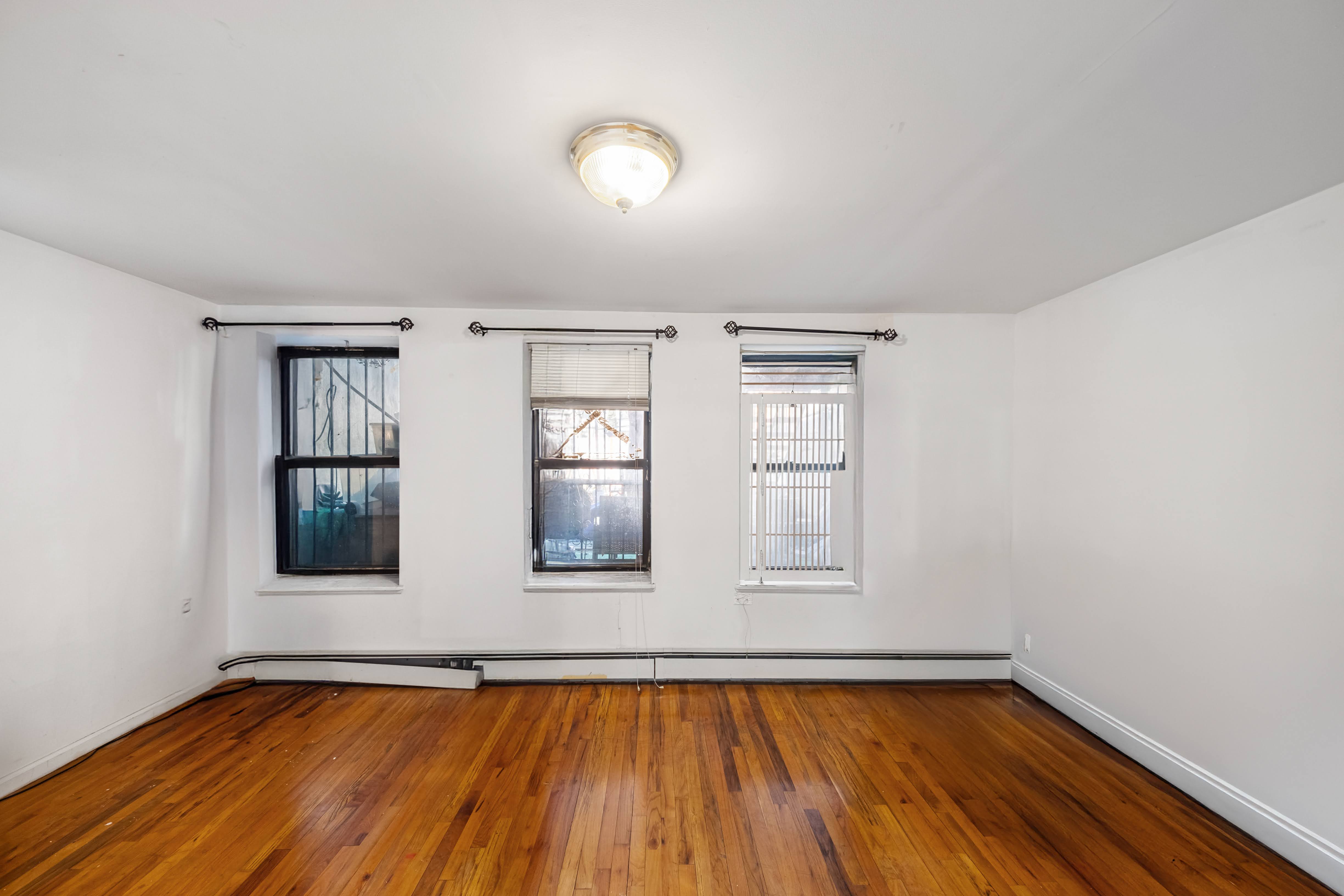275 Van Buren Street Brooklyn, NY 11221 - Photo 21 of 33 an empty room with wooden floor and windows