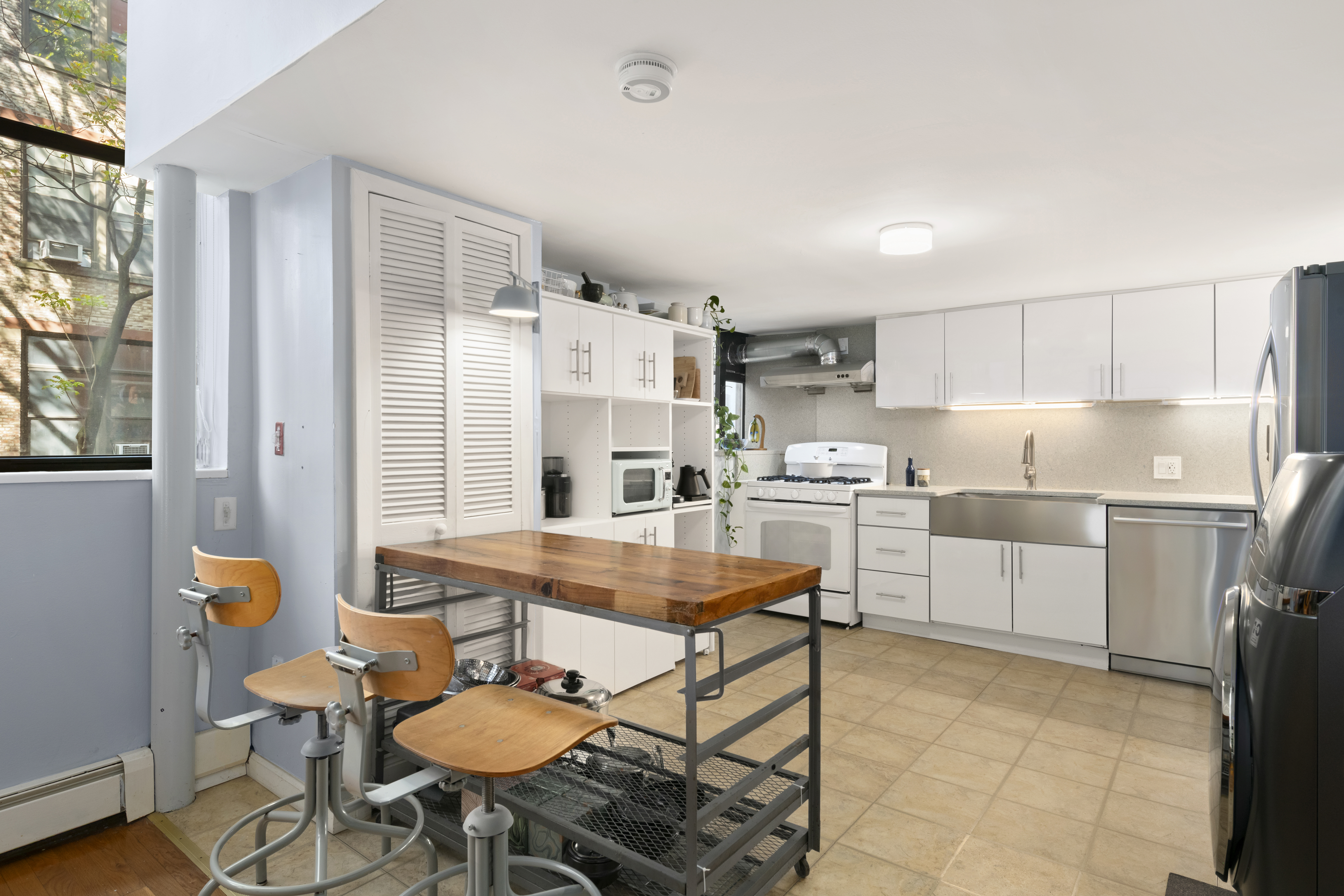 309 East 108th Street, Unit 2/D Manhattan, NY 10029 - Photo 5 of 12 a kitchen with a dining table chairs and refrigerator