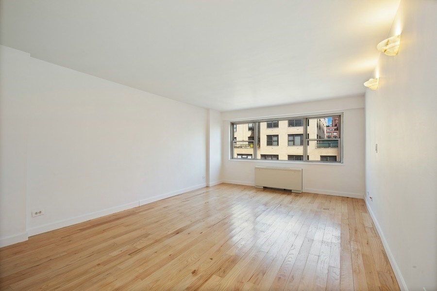 330 East 49th Street, Unit 11G Manhattan, NY 10017 - Photo 5 of 9 an empty room with wooden floor and windows