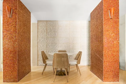 a patio with table and chairs and potted plants