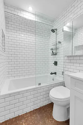 752 Jefferson Avenue, Unit GARDEN Brooklyn, NY 11221 - Photo 5 of 8 a bathroom with a toilet a sink a mirror a bathtub and shower