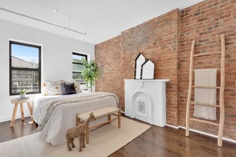 a spacious bedroom with a bed a dresser and window