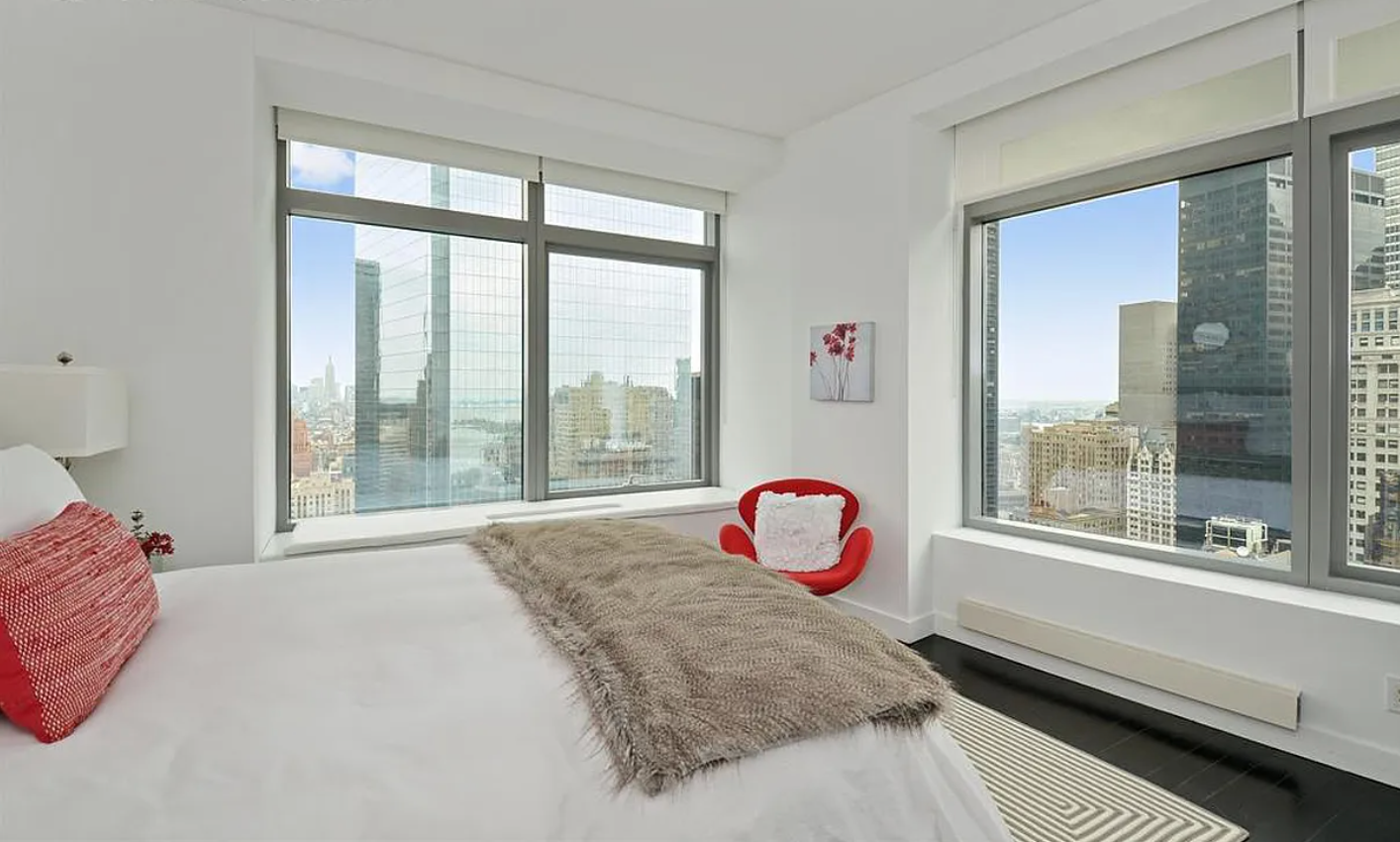 123 Washington Street, Unit 43F Manhattan, NY 10006 - Photo 3 of 8 a bed sitting in front of a window