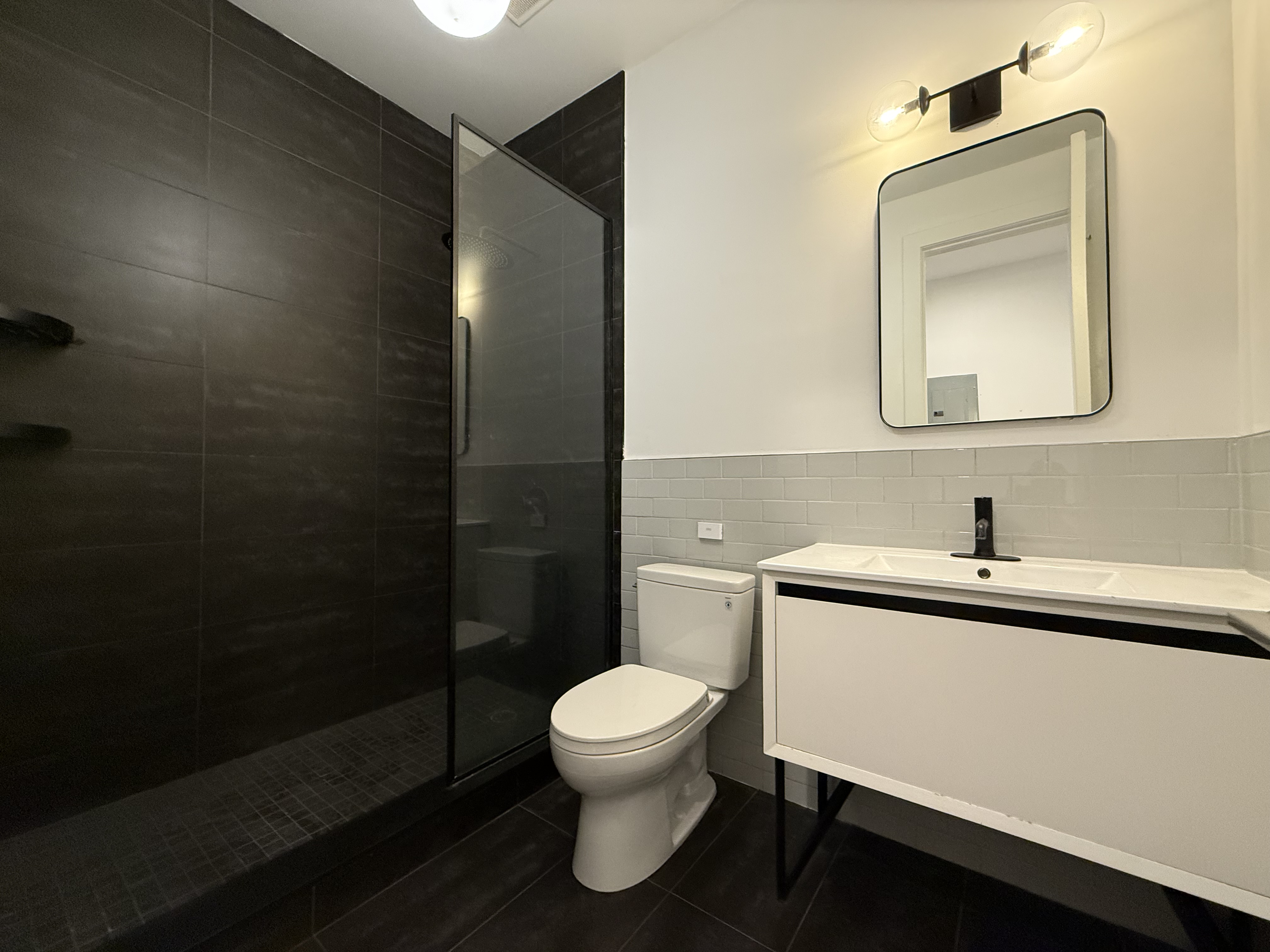 71 Cooper Street, Unit 2B Brooklyn, NY 11207 - Photo 4 of 4 a bathroom with a toilet a sink and mirror