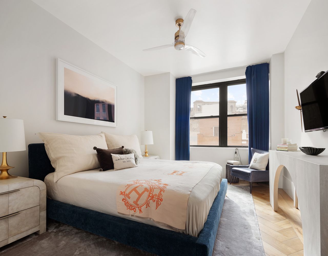 a bedroom with a large bed and a flat tv screen on dresser