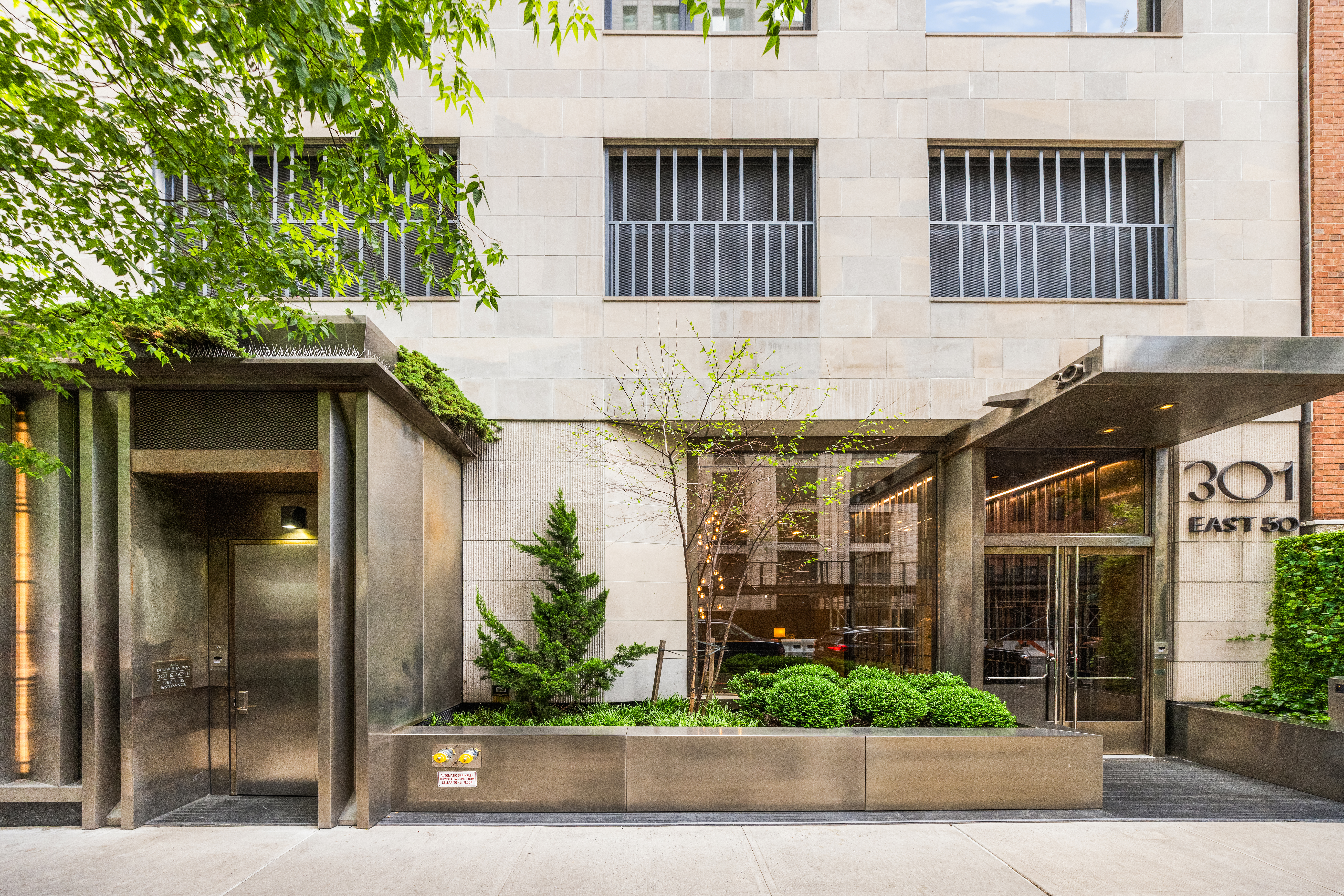 301 East 50th Street, Unit 8C Manhattan, NY 10022 - Photo 19 of 20 a front view of a building with a garden and plants