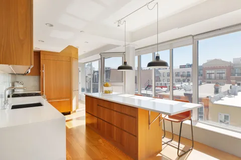 a large kitchen with a large window and stainless steel appliances