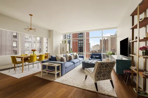 a living room with furniture a large window and a flat screen tv