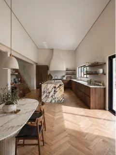 a kitchen with stainless steel appliances kitchen island granite countertop a table chairs in it and wooden floors