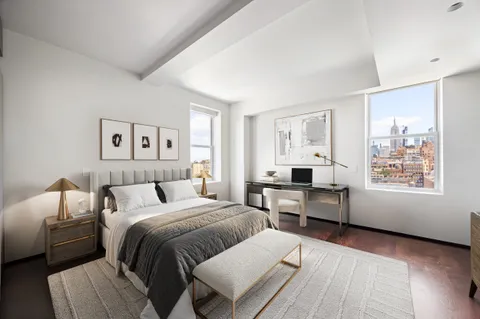 a bedroom with a large bed and wooden floor