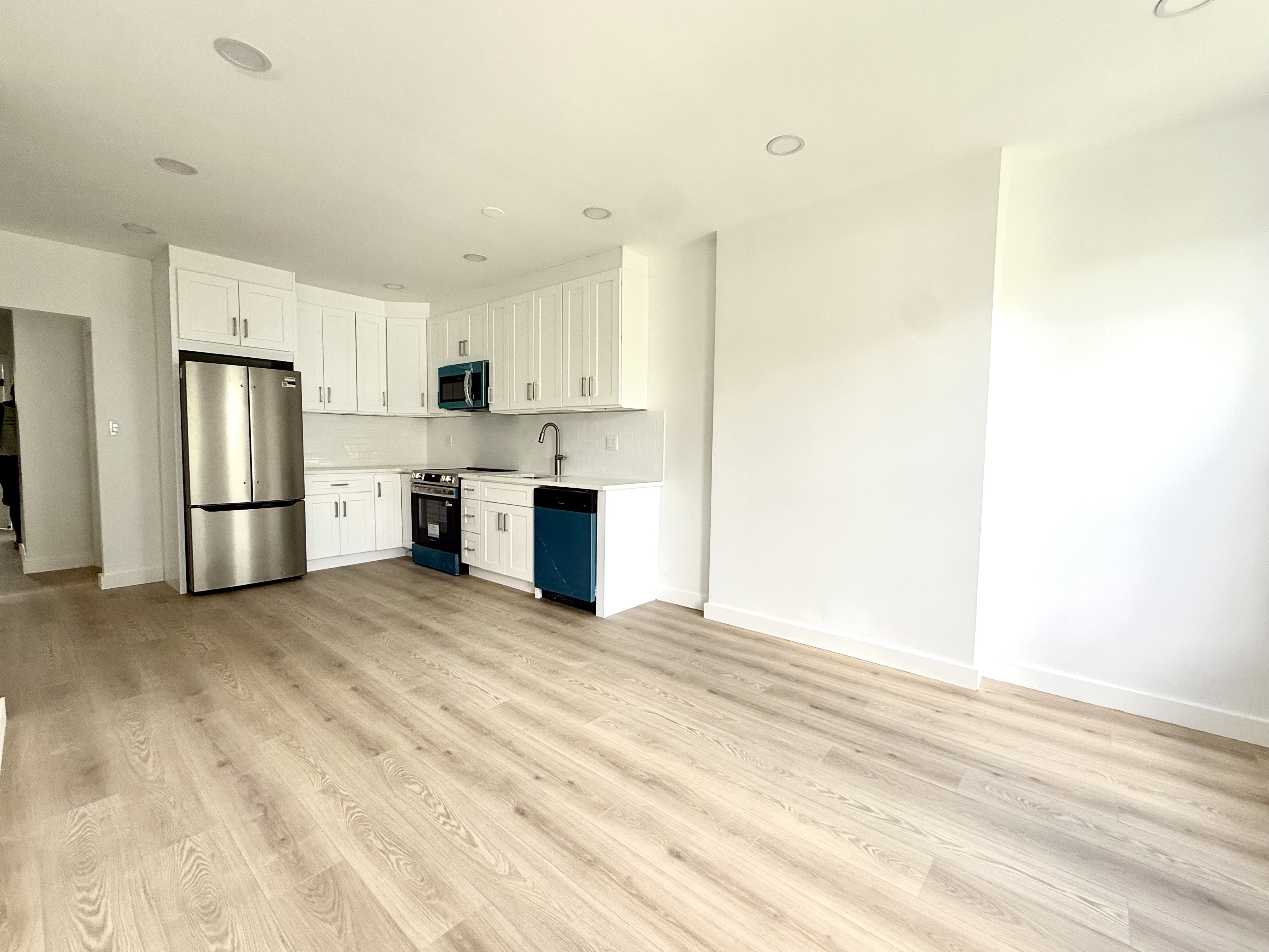 985 Rogers Avenue, Unit 3 Brooklyn, NY 11226 - Photo 3 of 10 a view of kitchen with refrigerator stove microwave and cabinets