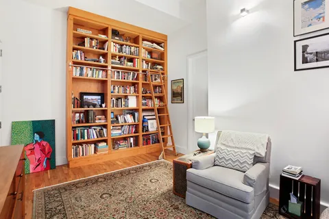 a living room with furniture and a book shelf