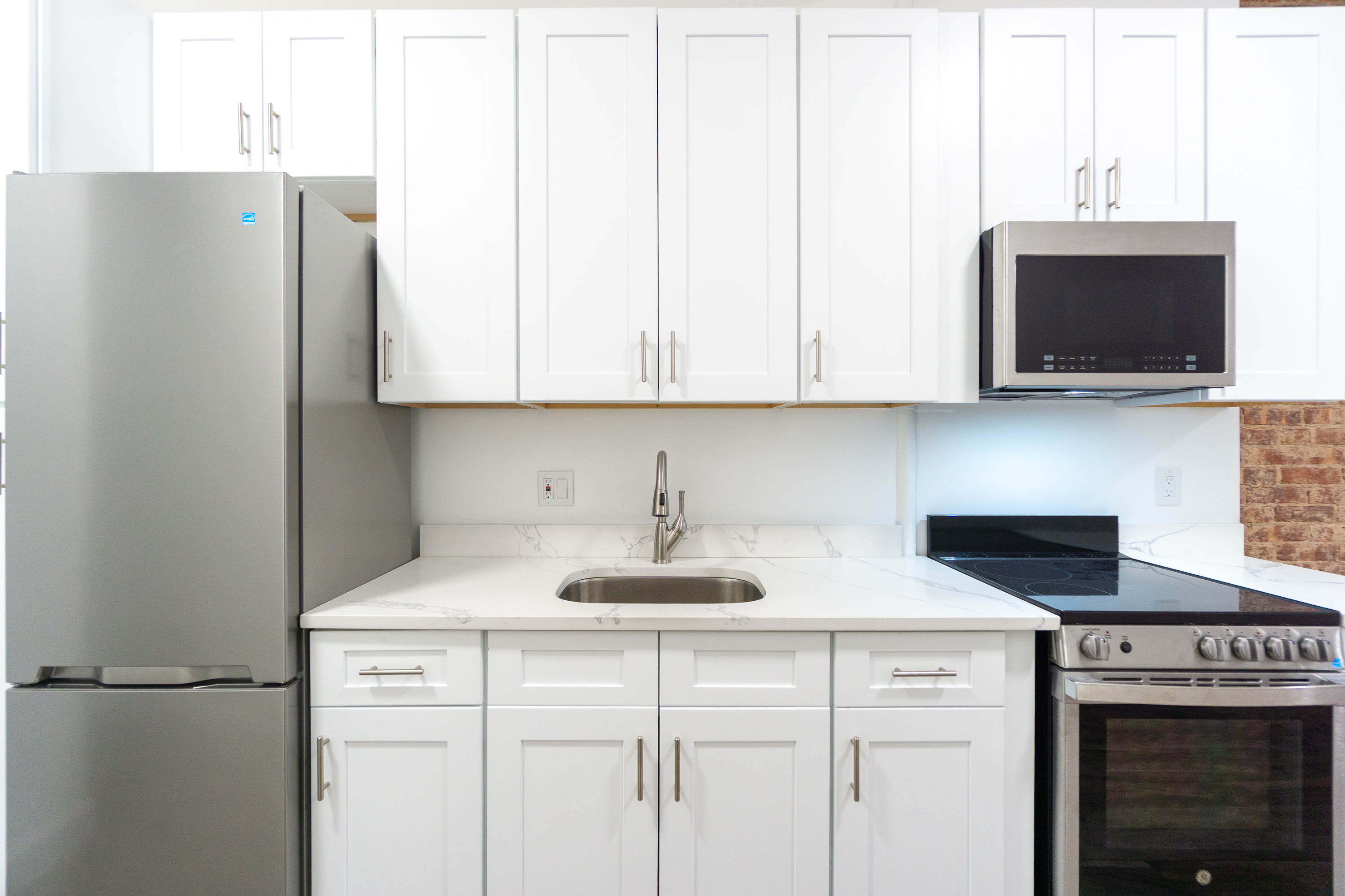 213 East 5th Street, Unit 4 Manhattan, NY 10003 - Photo 7 of 18 a kitchen with stainless steel appliances white cabinets and a refrigerator