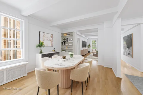 a dining room with furniture a window and wooden floor