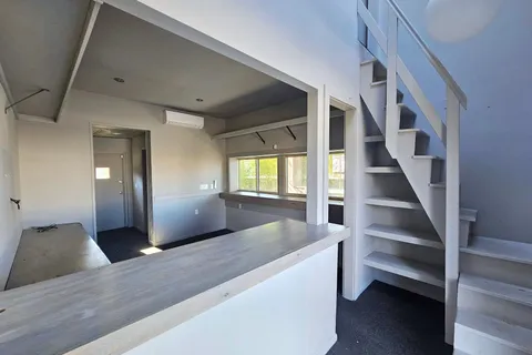 a view of a room with an empty space and a window