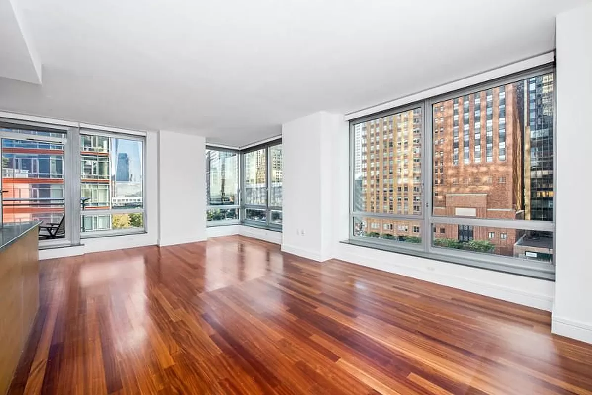 30 West Street, Unit 6B Manhattan, NY 10004 - Photo 7 of 13 a view of an empty room with wooden floor and a window