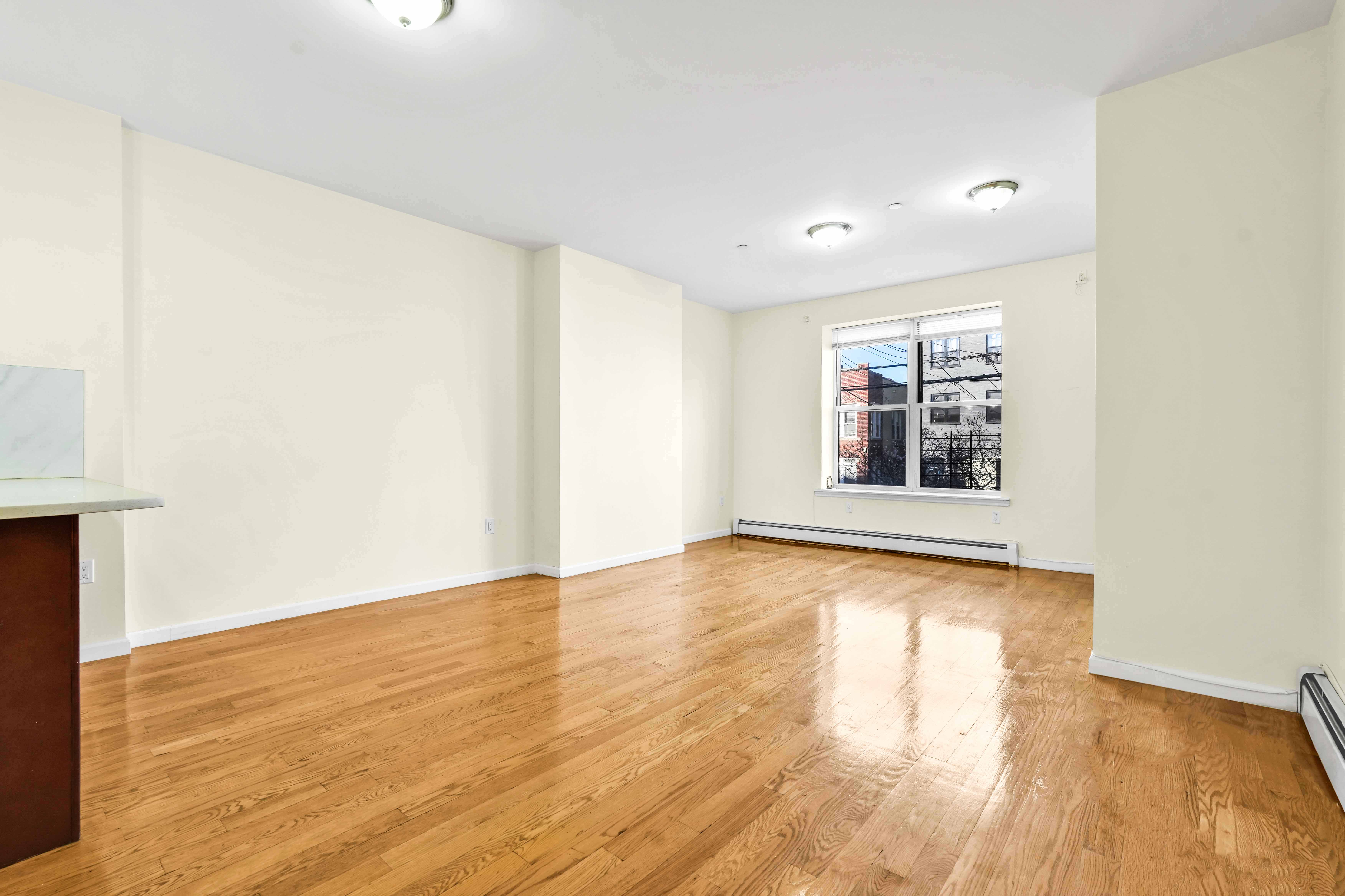 1892 Bergen Street, Unit 2 Brooklyn, NY 11233 - Photo 10 of 24 a view of an empty room with wooden floor and a window