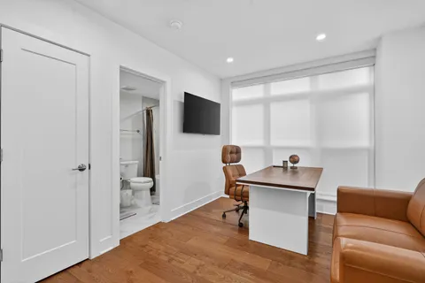 a work room with furniture and a flat screen tv