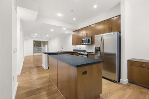 a kitchen with stainless steel appliances granite countertop a refrigerator and a stove