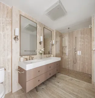 a bathroom with a double vanity sink mirror and shower