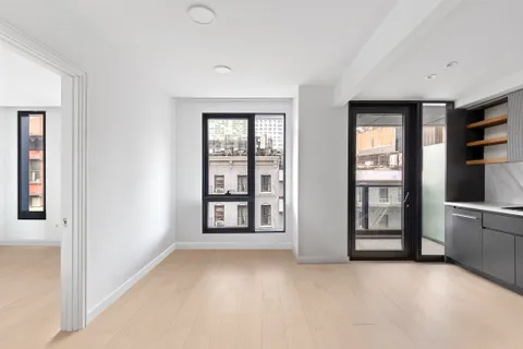 an empty room with windows and cabinet