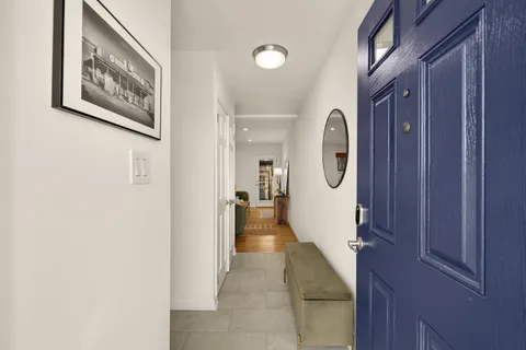 a hallway with painting on the wall and a large mirror