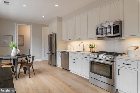 a kitchen with stainless steel appliances a stove microwave and cabinets